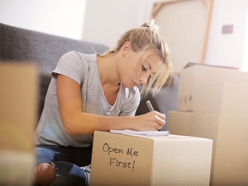 woman making move plans surrounded by moving boxes